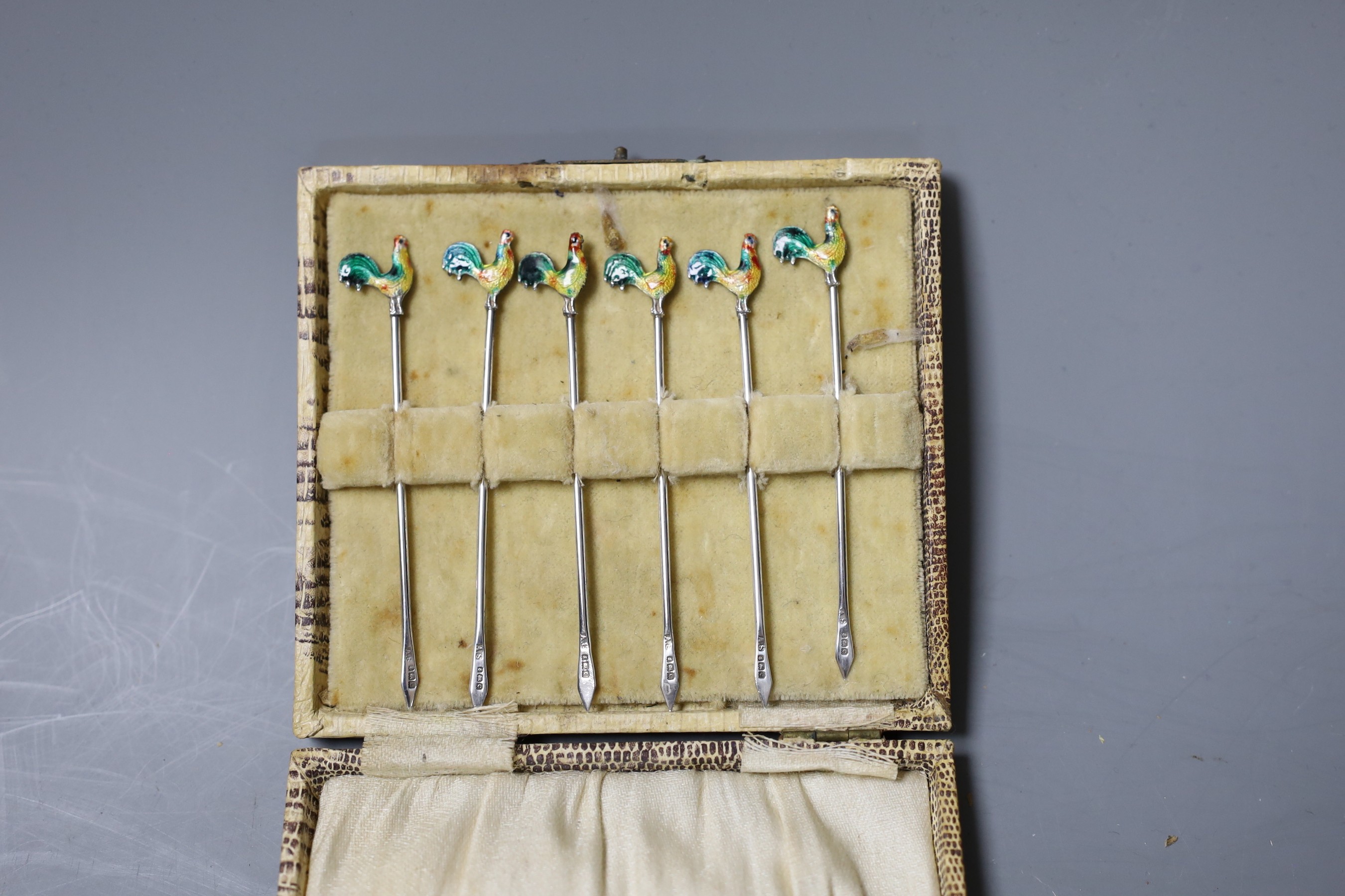 A cased set of six George V silver and enamel ‘Cockerel’ terminal cocktail sticks, Birmingham, 1927.